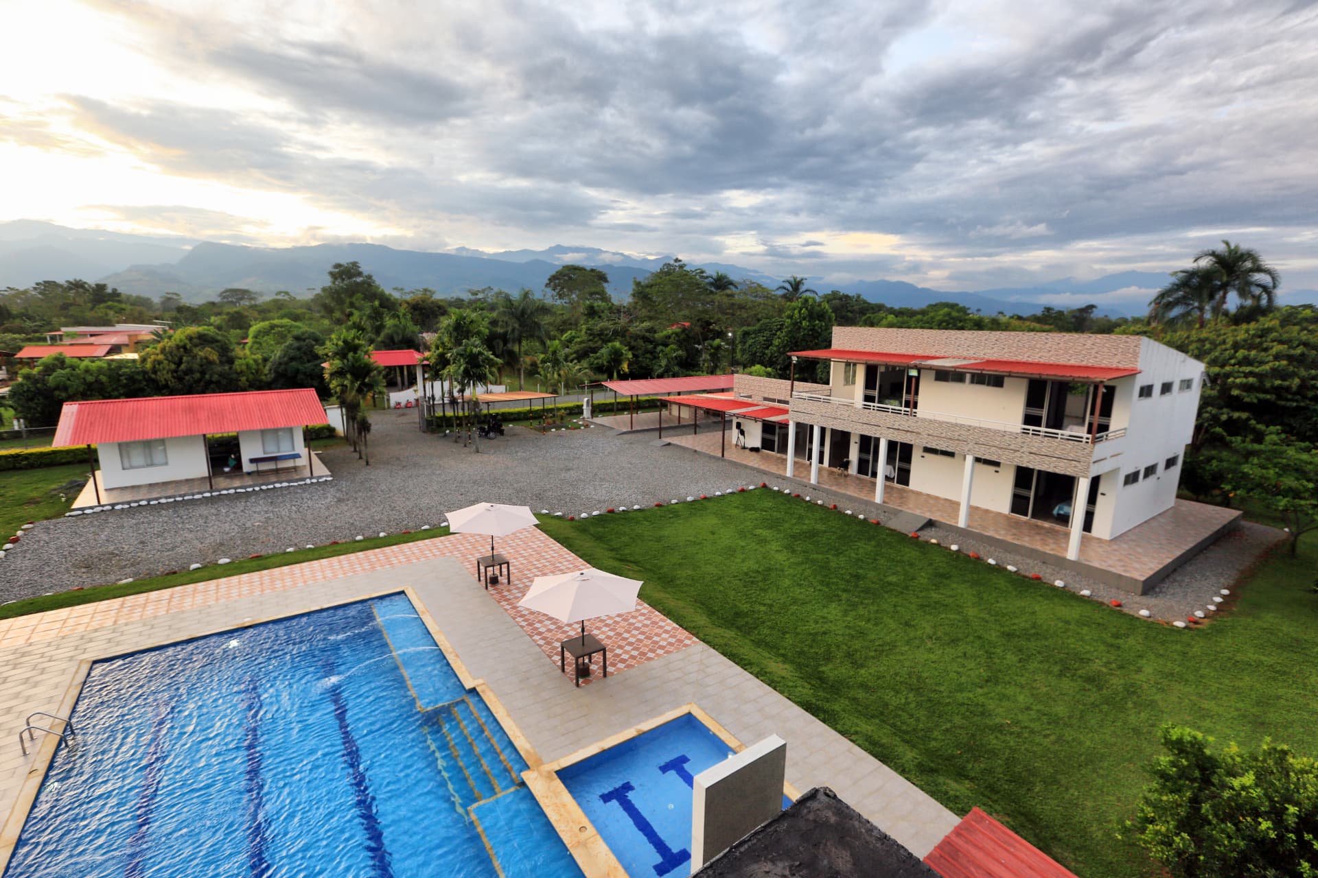 Vista aérea de Finca Mana con piscina, jardín y montañas al fondo