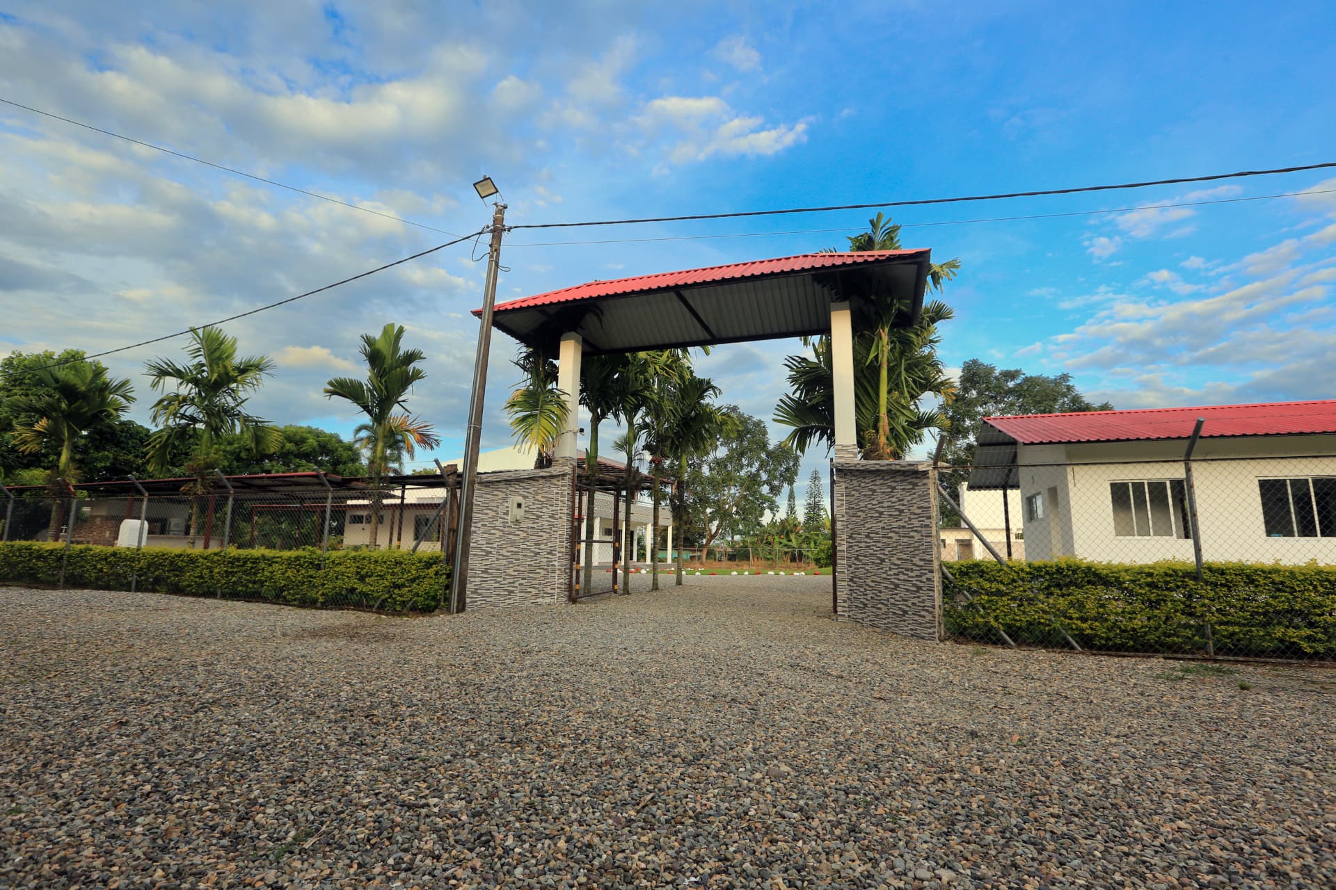 Portada de entrada de Finca Mana rodeada de palmas