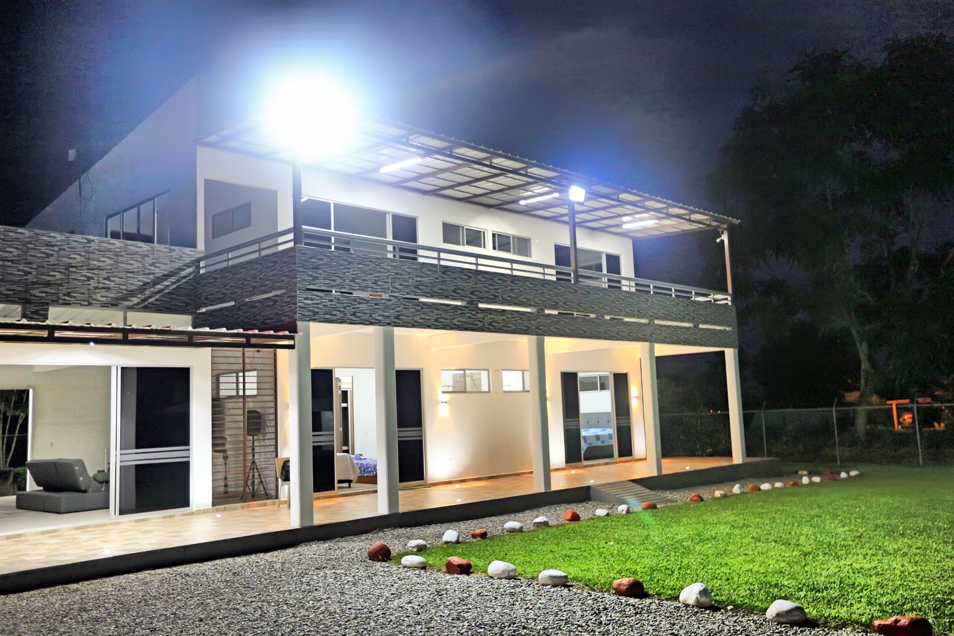Casa principal de dos pisos de Finca Mana iluminada de noche