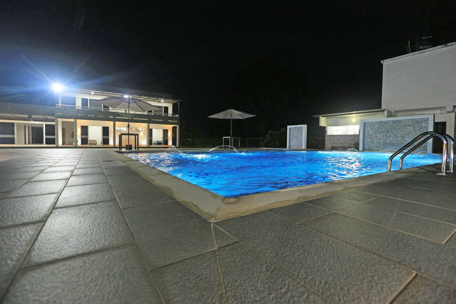 Piscina de Finca Mana iluminada de noche con chorros de agua